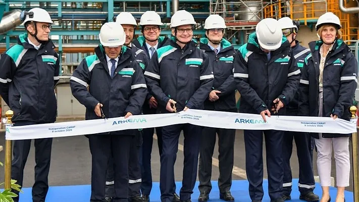 Picture of men in blue cutting a ribbon