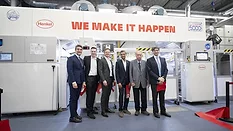 Picture of five men standing in front of a machine