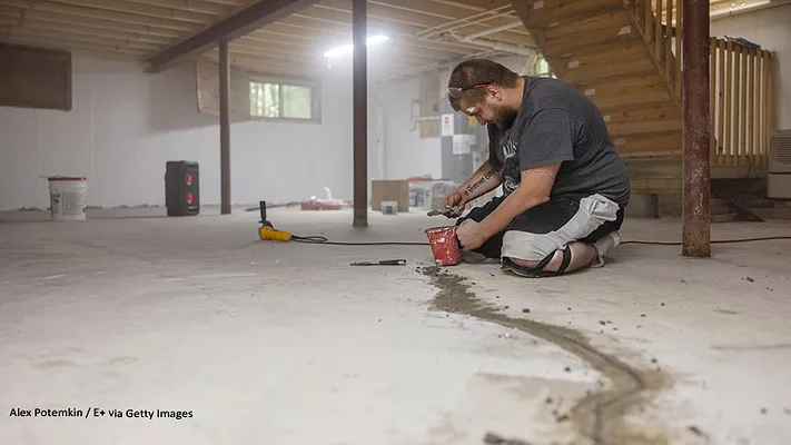 Image of man repairing a basement concrete floor