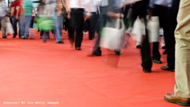 Image of people standing on pink carpet at trade show