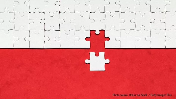 white puzzle piece added to larger puzzle on red background
