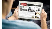 news-on-tablet-GettyImages-1158778963 (1).jpg Man reading news on tablet